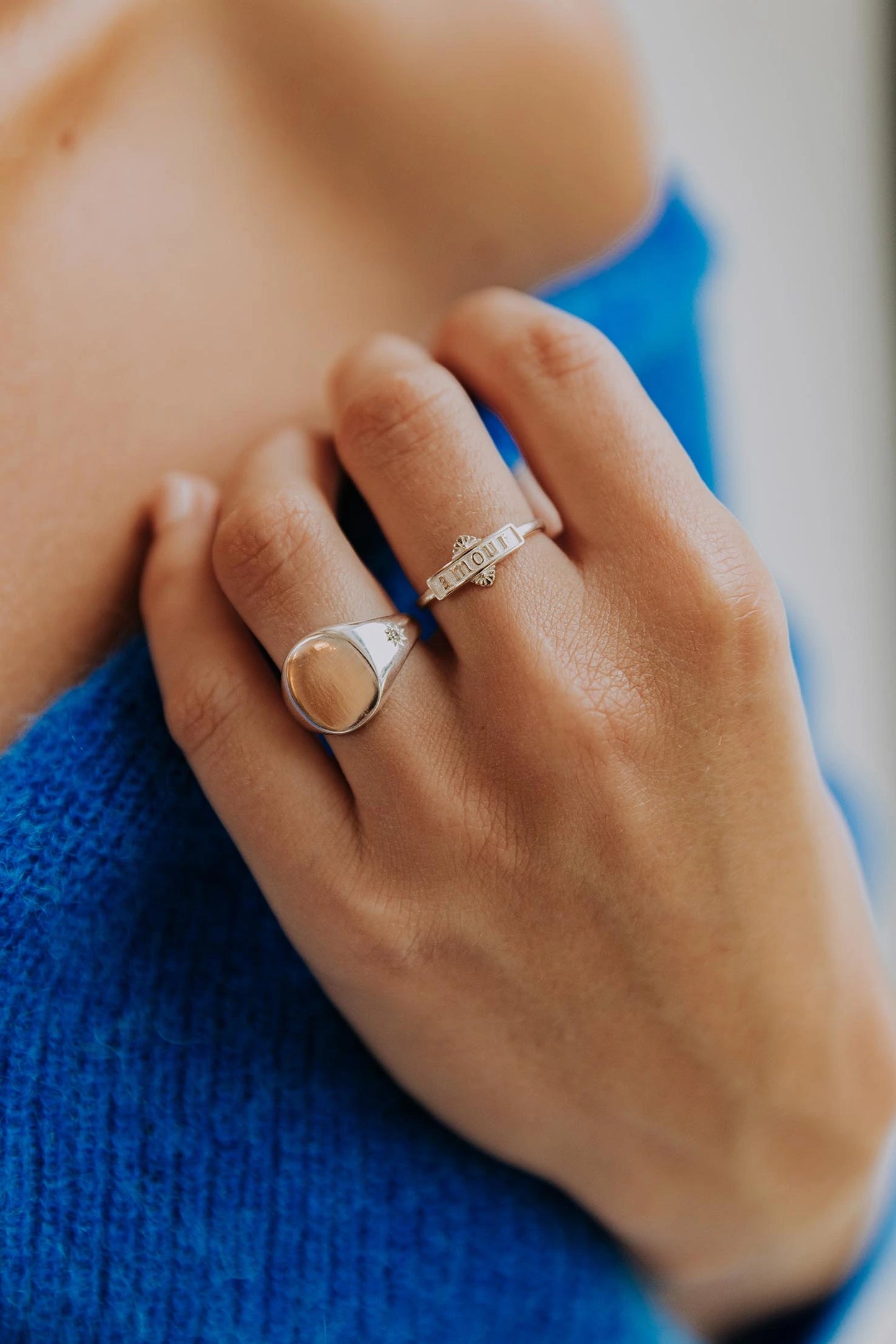 Bague femme collection amour en argent portant l'inscription gravée amour portée sur une femme portant un vêtement bleu