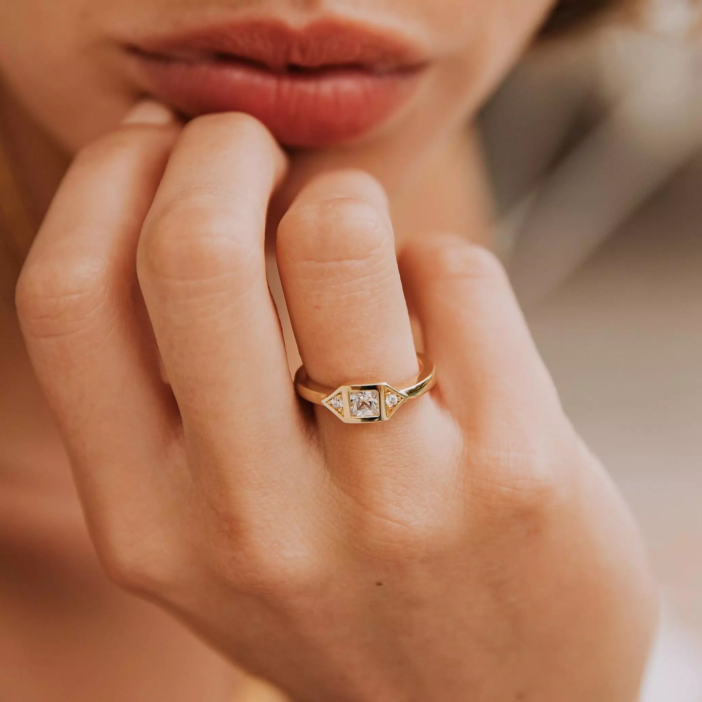 bague femme plaqué or sertie de pierres de zircons couleur cristal portée par une femme séductrice