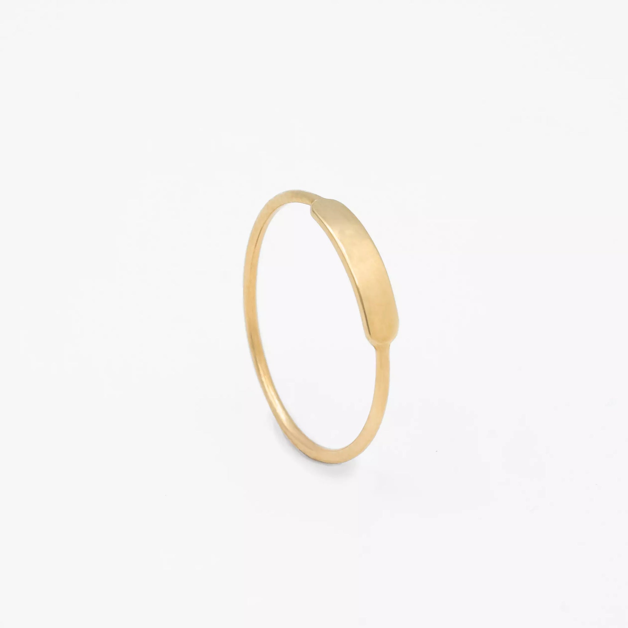 bague en or ronde identité personnalisable en gravure debout sur fond blanc