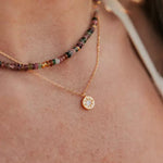 collier femme en vermeil collection mon soleil à gravure personnalisable de forme ronde serti d'un zircon de couleur cristal dans une étoile gravée porté au cou