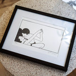 illustration encadrée 7ème ciel par Agathe Sorlet en noir et blanc de deux amants qui s'embrassent posée sur une table