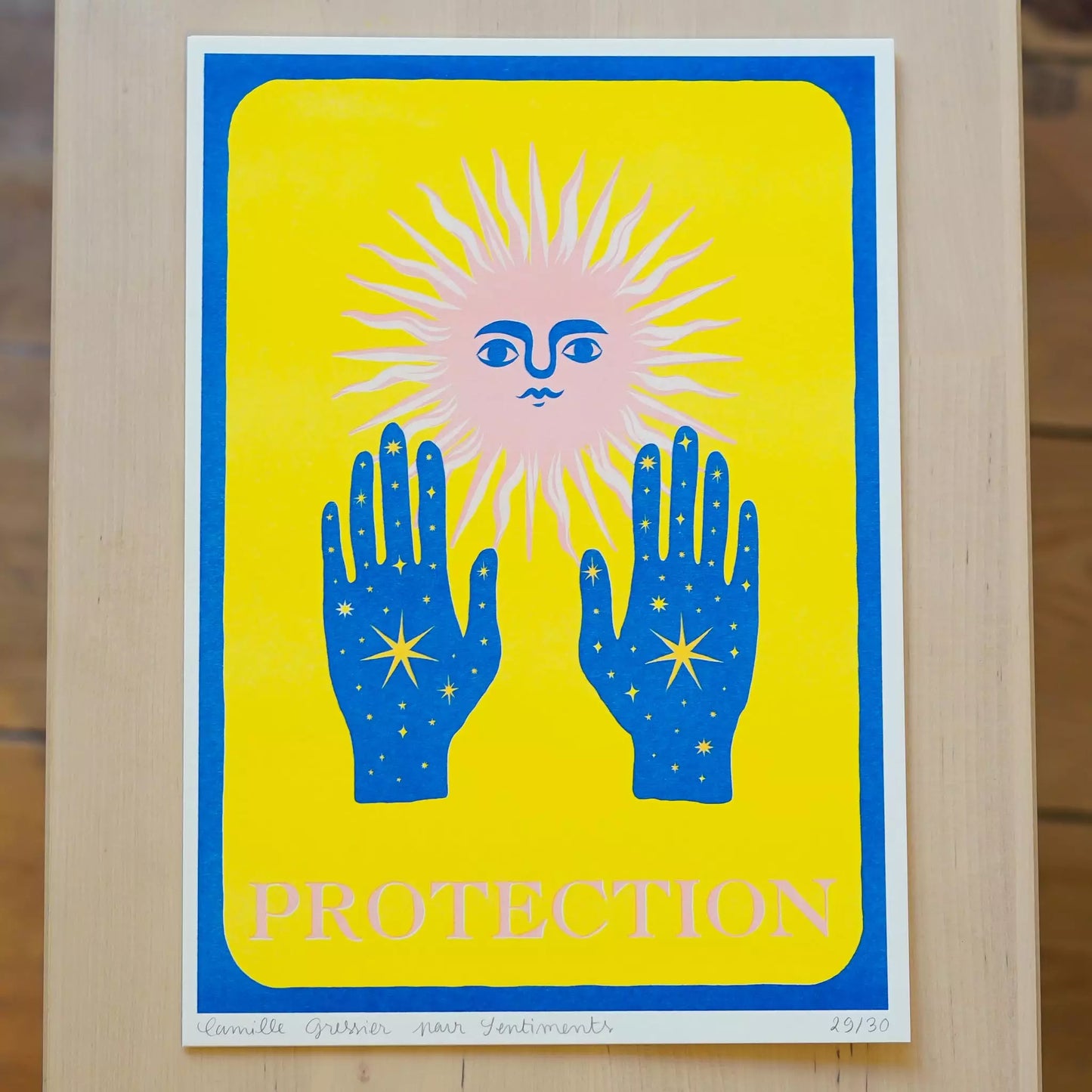 Illustration Protection de Camille Gressier d'un soleil stylisé avec un visage portant ses mains remplies d'un ciel bleu nuit avec des étoiles en avant sur fond jaune avec la mention PROTECTION en bas de l'affiche