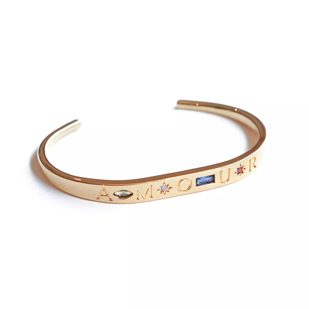 bracelet jonc collection amour plaqué or gravé du mot amour chaque lettre est séparé par des pierres de zircons de couleur péridot bleue nuit fuchsia et cristal