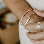 bracelet jonc homme en argent à gravure personnalisable serti d'une pierre turquoise porté sur un poignet